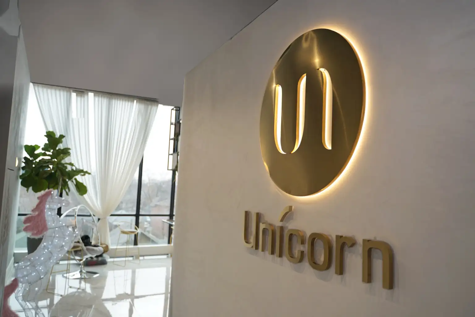 Unicorn Cosmetic Clinic reception: the lit logo and the wordmark on the wall
